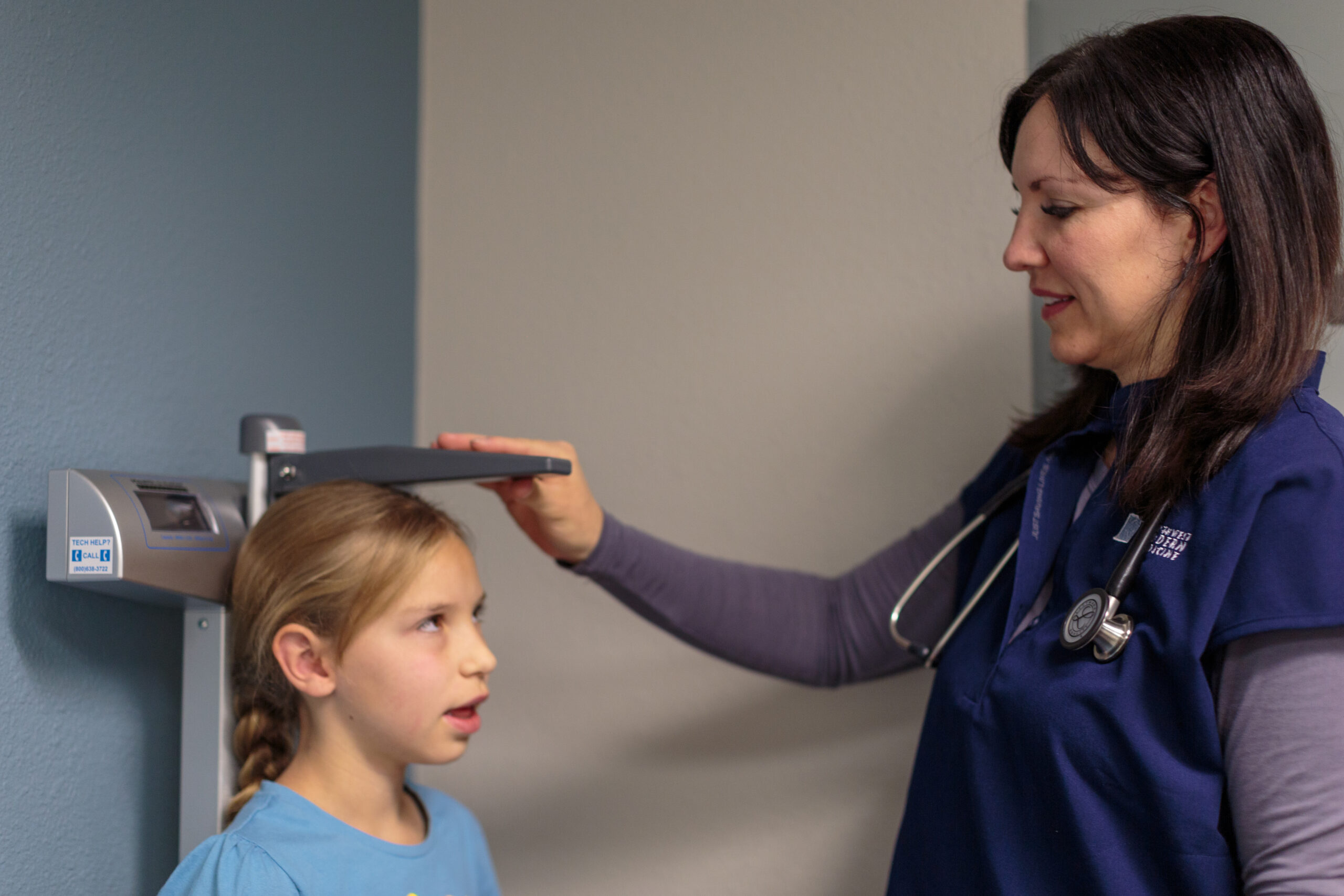 Image of a young girl getting her height measured before her routine checkup